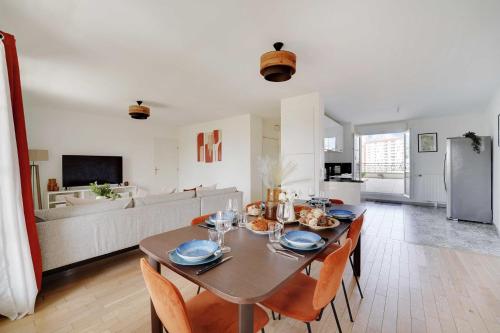 une salle à manger avec une table et des chaises et une cuisine dans l'établissement Superb 3BR with Terraces – Puteaux La Défense, à Puteaux