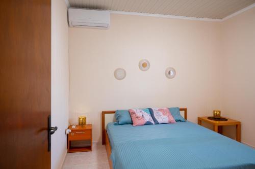 Schlafzimmer mit einem Bett mit blauer Bettwäsche in der Unterkunft MareAntoanetta in Nea Kallikratia