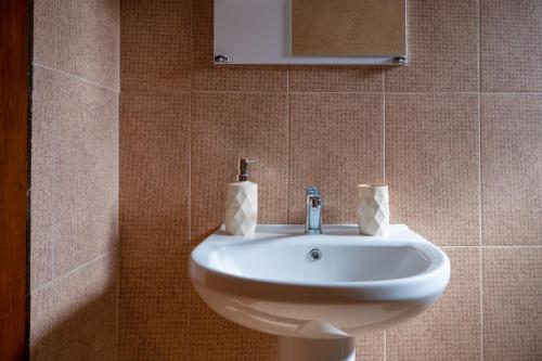 ein weißes Waschbecken in einem Badezimmer mit einem Spiegel in der Unterkunft MareAntoanetta in Nea Kallikratia