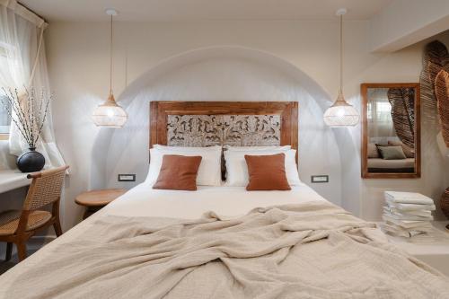 Un dormitorio con una gran cama blanca con dos almohadas. en Chic Elysium - Serenity, en Naxos Chora