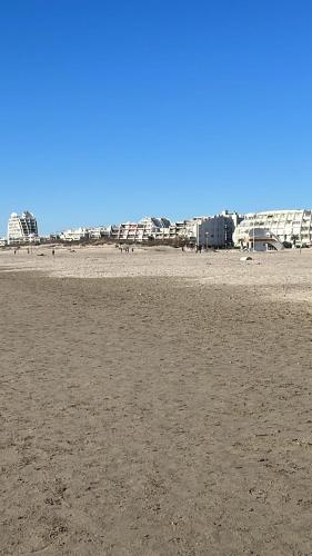 une plage de sable avec des bâtiments en arrière-plan dans l'établissement Joana's House, à La Grande Motte
