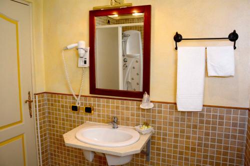 a bathroom with a sink and a mirror at Albergo Dimora Storica Antica Hostelleria in Crema