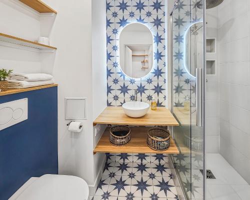 une salle de bain avec un lavabo et un miroir dans l'établissement South-facing terrace, direct beach access, à Cabourg