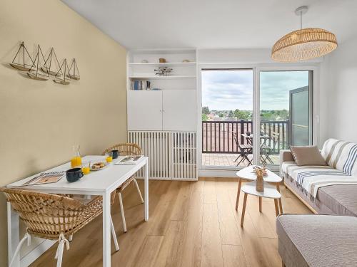 un salon avec une table blanche et un canapé dans l'établissement South-facing terrace, direct beach access, à Cabourg