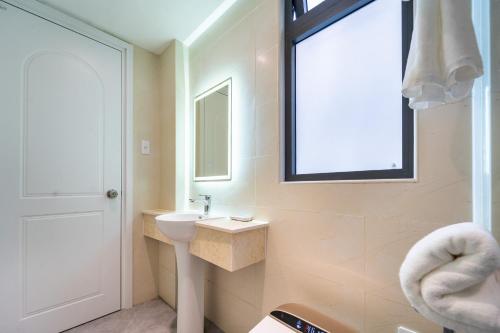a bathroom with a sink and a toilet and a window at Nicecy Hotel - Trương Quyền in Ho Chi Minh City