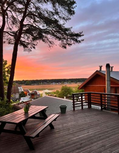 a wooden deck with a picnic table and a tree at Pineplace residence in Jūrmala