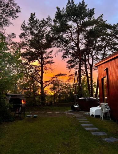 a sunset over a yard with a house and trees at Pineplace residence in Jūrmala