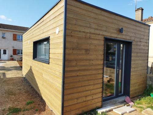 a small wooden house with two windows at Tiny house neuve, confortable et parking gratuit in Poitiers