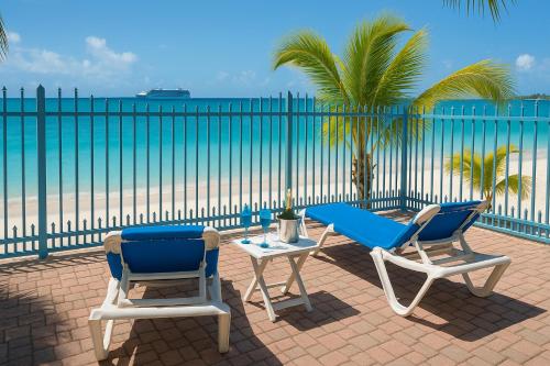 two chairs and a table on a patio with the ocean at Villas on Great Bay VILLA FOXIE in Philipsburg