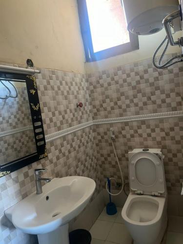 a bathroom with a sink and a toilet and a window at Balew Guest House in Bahir Dar
