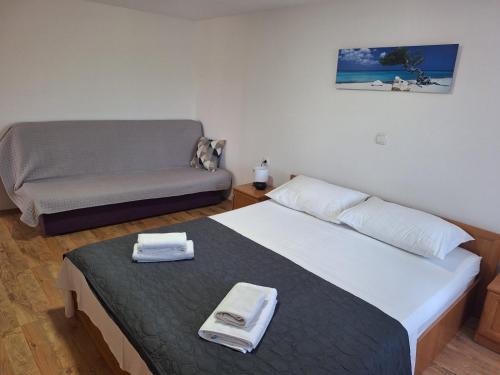 a small bedroom with a bed and a couch at Holiday Home Hidden Hill in Lopar