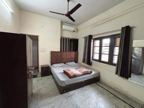 デヘラードゥーンにあるShree Ji Home Stay Peaceful & Comfortable Rooms in Dehradunのベッドと天井扇風機のある寝室