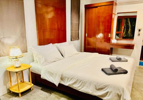 a bedroom with a bed with two towels on it at Chook Dee Resort in Baan Tai