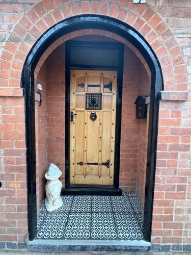an entrance to a brick building with a wooden door at The Plum Tree - 5 luxury modern bedrooms in Melton Mowbray