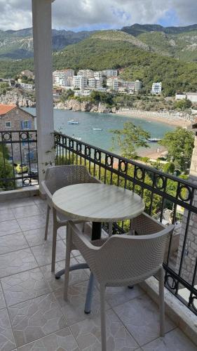 a table and chairs on a balcony with a view at Apartments Mitrovići Miločer in Sveti Stefan