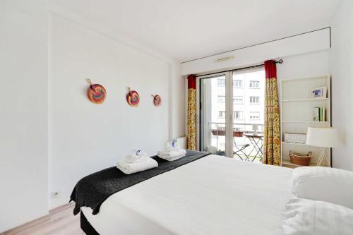 une chambre blanche avec un grand lit et une fenêtre dans l'établissement Charming apartment -1BR-2P- Boulogne-Billancourt, à Boulogne-Billancourt
