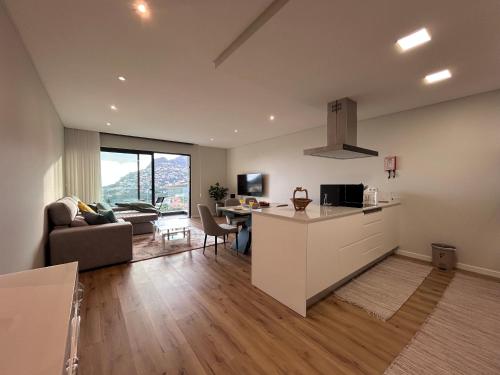 a kitchen and living room with a couch and a table at Saraiva Hills Ocean View Penthouse in Câmara de Lobos