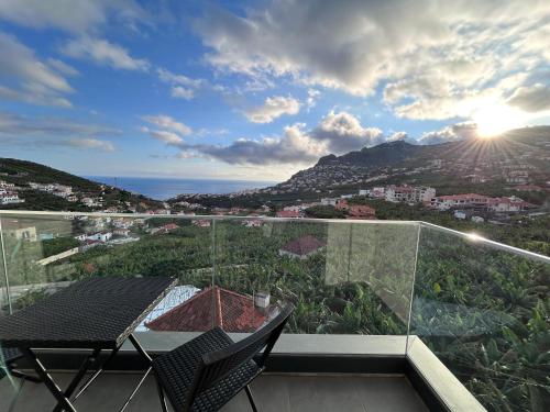 a balcony with a table and a view of the ocean at Saraiva Hills Ocean View Penthouse in Câmara de Lobos