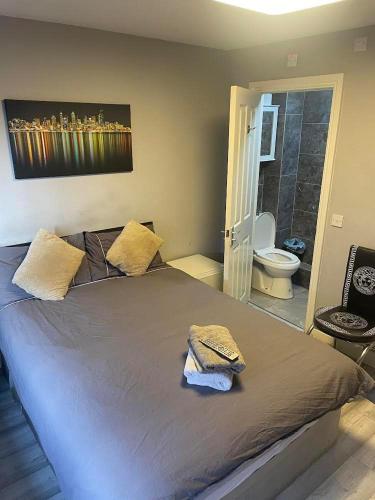 a bedroom with a large bed and a bathroom at Nightingale Ensuite Budget Rooms in Woolwich