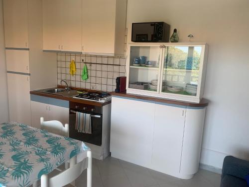 a small kitchen with a stove and a counter top at CASA STINTINO tra Ginepri e Mare in Stintino