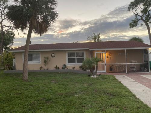 a house with a palm tree in the yard at Englewood BeachHouse in Englewood