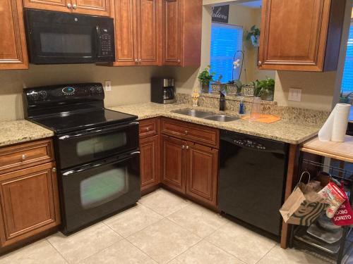a kitchen with a black stove and a sink at Englewood BeachHouse in Englewood