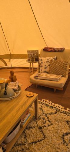 a living room with a couch and a table at Sŵn Y Môr bell tent