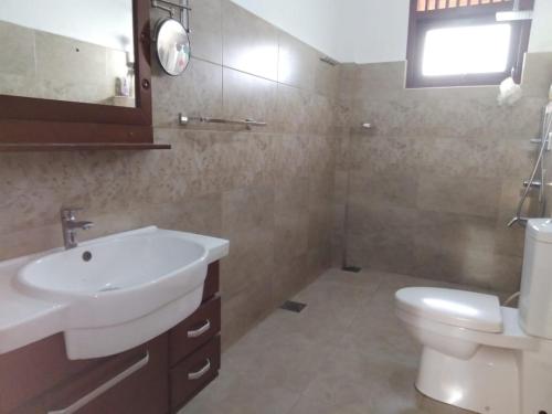 a bathroom with a sink and a toilet at Green Court Villa in Talawatugoda