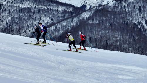 a group of people skiing down a snow covered slope at Flora Handüzü Resort & Wellness Bungalow Hotel in Rize