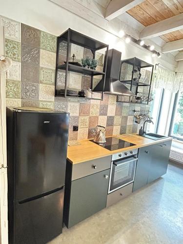 a kitchen with a stainless steel refrigerator and a stove at Szumidomki strefa z jacuzzi sauna widok na potok las in Zawoja