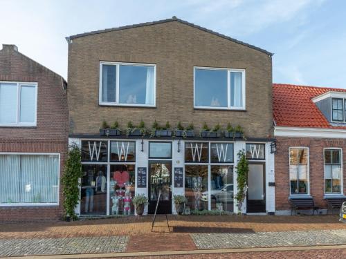 a large brick building with windows and plants at Lovely, modern, 4-person apartment in the heart of Koudekerke in Koudekerke
