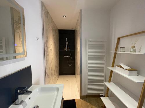a white bathroom with a sink and a shower at Le Bras d 'Or in Pont-lʼÉvêque