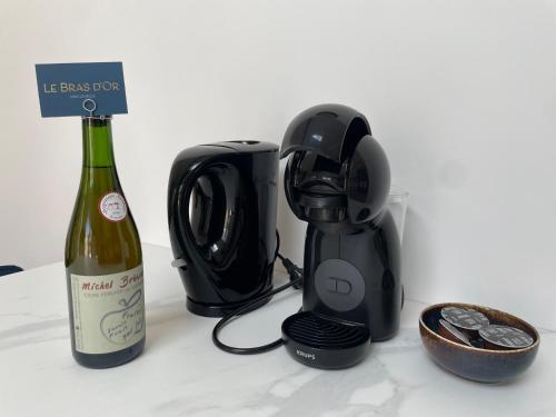 a bottle of wine sitting next to a blender and a bottle of wine at Le Bras d 'Or in Pont-lʼÉvêque