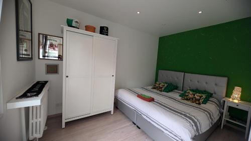 a small bedroom with a green wall and a bed at Chemin des Vignerons in Metz
