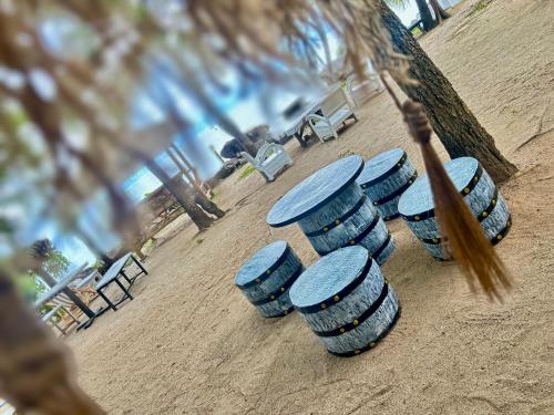 a group of blue barrels sitting in the dirt at Chook Dee Resort in Baan Tai