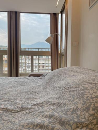 une chambre avec un grand lit et une grande fenêtre dans l'établissement Charmant studio avec vue montagne, à Roquebrune-Cap-Martin