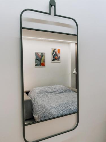 - un miroir reflétant un lit dans une chambre dans l'établissement Charmant studio avec vue montagne, à Roquebrune-Cap-Martin