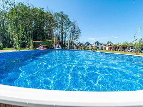 una grande piscina con acqua azzurra di Holiday cottages air conditioning pool Niechorze a Niechorze
