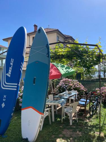 two surfboards are standing next to a table and chairs at Villa Lakeview Paradise in Peštani
