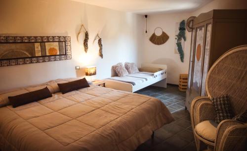 a bedroom with a large bed and a couch at Mecana Home - 20 minuti dalle terme di Saturnia in Manciano