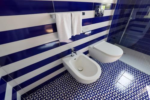 a blue and white bathroom with a toilet and a bidet at Hotel Boutique Ideal in Ischia