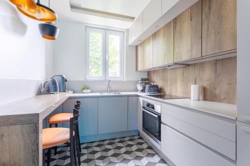 une cuisine avec des armoires blanches et des appareils bleus dans l'établissement 4-room apartment Place de la Mairie - City Center, à Bois-Colombes
