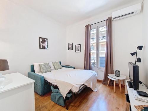 une chambre blanche avec un lit et une télévision dans l'établissement Nestor&Jeeves - AZUR STUDIO - Near Promenade des Anglais, à Nice