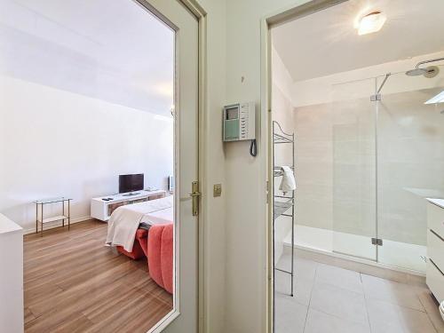 une chambre avec un lit et une porte coulissante en verre dans l'établissement Nestor&Jeeves - STUDIO RENOIR - Central location, à Nice
