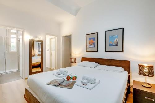1 dormitorio con 1 cama blanca grande y 2 libros en Valentina Home - Happy Rentals, en Lugano