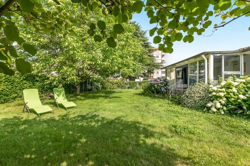 a yard with two chairs and a house at Villa Anita - Happy Rentals in Caslano