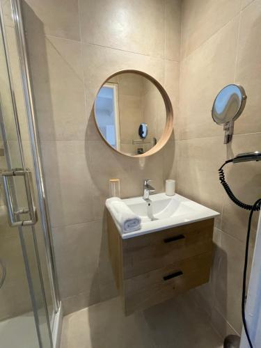 une salle de bain avec un lavabo et un miroir dans l'établissement Appartement 2 BED SWAN HOUSE Cannes la croisette, à Cannes