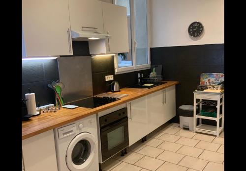une cuisine avec un lave-linge et un lave-linge dans l'établissement La maison des arènes, à Arles