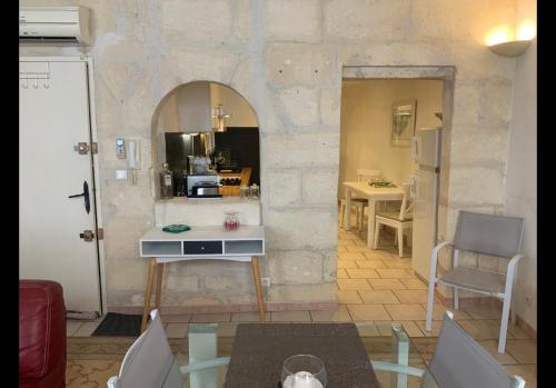 un salon avec une table et une cuisine dans l'établissement La maison des arènes, à Arles