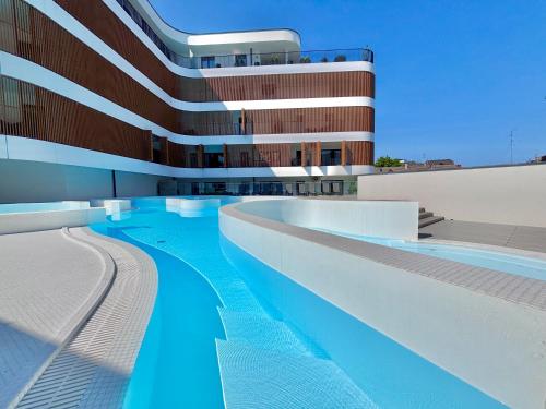 a swimming pool in front of a building at Baltic Waves Resort & SPA Międzyzdroje 3 in Międzyzdroje
